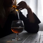 silhouette of anonymous alcoholic woman person drinking behind glass of alcohol. Alcohol addiction and Social problem - with alcoholism and poisoning