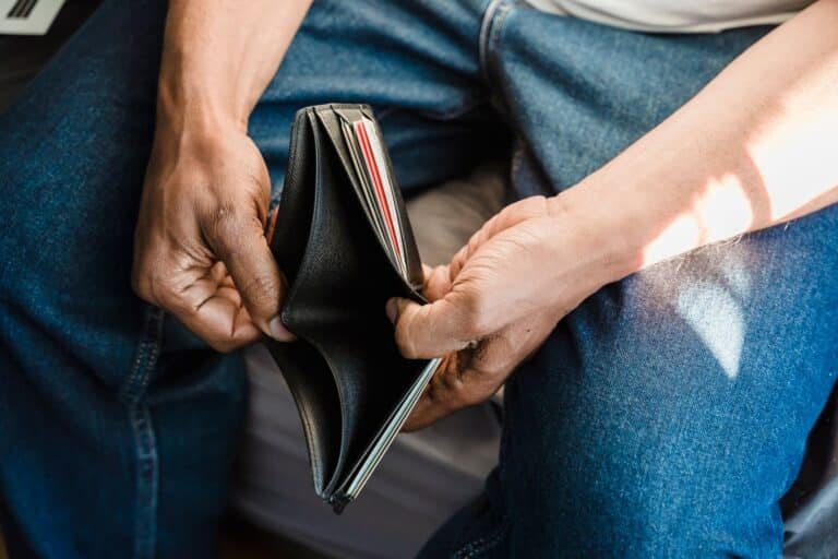 Mãos abrindo carteira vazia representando impacto financeiro do vício em apostas